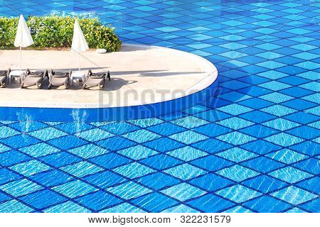 Swimming Pool. View On The Blue Swimming-pool And Ambrellas On The Hotel Terrain.