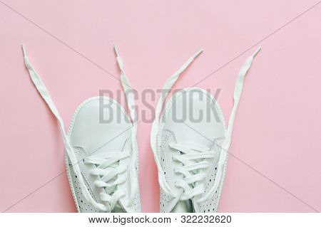 White Sneakers On A Pink Background With Untied Laces. Flat Lay. Top View. Ope Space.