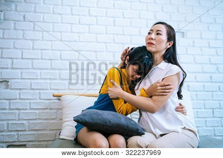 Asian Mother Comforting Crying Teenage Daughter In Miserable, Stressed, Depressed, Sad State Of Mind