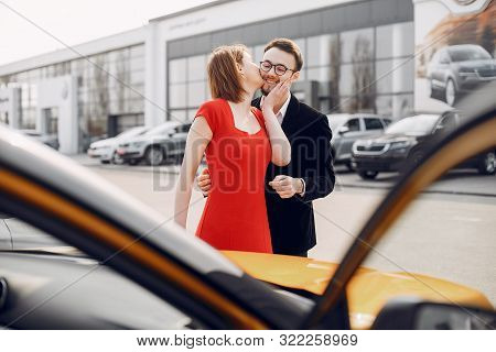 Stylish And Elegant Couple In A Car Salon