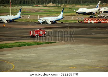 Fire Truck On The Runway Near The Aircraft. Airport Rescue Service. Firefighters And Fire Department