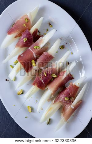 Still life of jamon serrano with yellow melon