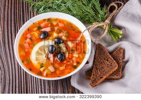 Traditional Russian Meat Soup Solyanka In Bowl On Rustic Wooden Table