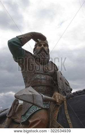 Russia, Village Irbeyskoye, July 2019: Sculpture Russian Knights On The River Bank. Hero Of Russian 