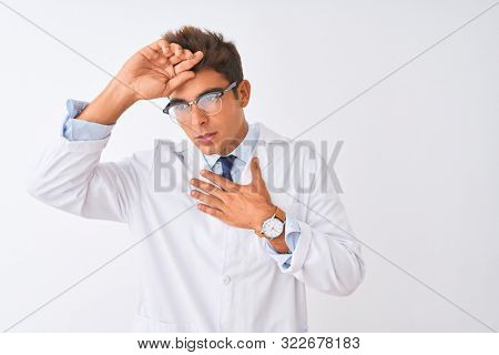 Young handsome sciencist man wearing glasses and coat over isolated white background Touching forehead for illness and fever, flu and cold, virus sick
