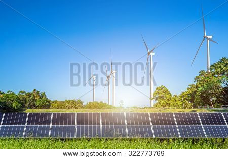 Solar Panels With Wind Turbines Against Mountanis Landscape Against Blue Sky With Clouds,alternative