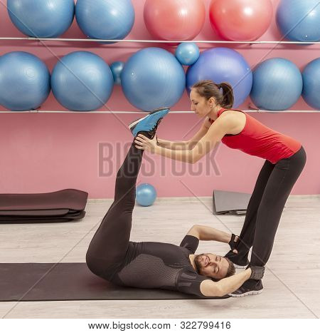 Young Man Helped By His Coach Doing Stretching Exrcises In A Gym.