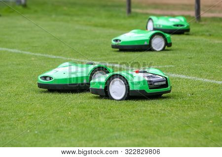 Oosterbeek, Netherlands - July 11, 2018: Automatic Robotic Lawnmower On Green Grass In The Stadium. 