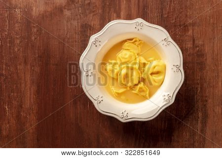 Italian Tortellini With Vegetable Broth, Shot From Above On A Dark Rustic Wooden Background With A P