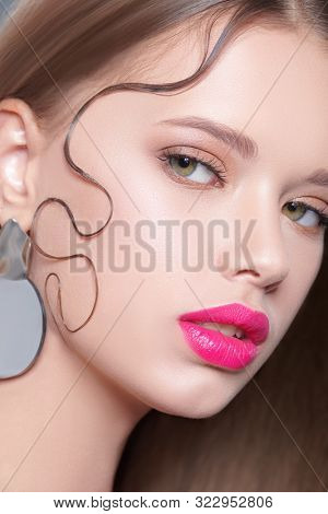 Beauty portrait, hair styling. Close-up of a beautiful young woman with fresh shining make-up and refined elegant hairstyle.