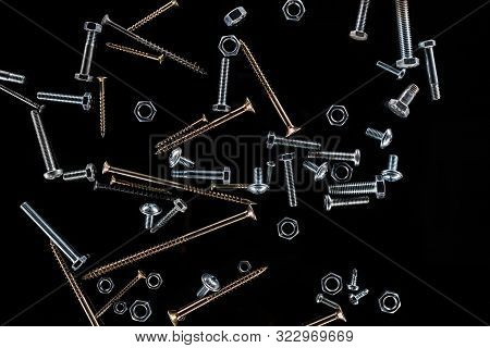 Top View Of Scattered Nuts, Bolts And Studs Isolated On Black