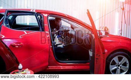 Car Service Worker Cleans Interiror With Steam Cleaner