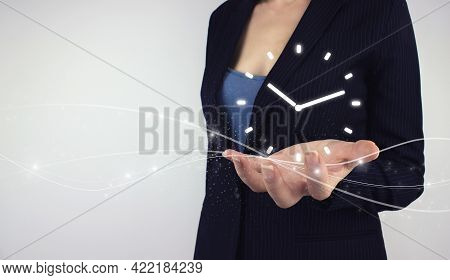 Time Management Concept. Hand Hold Digital Hologram Clock Time Symbol On Grey Background. Efficiency