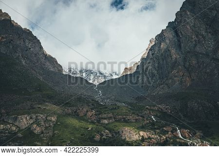 Atmospheric Landscape With Mountain Stream In Narrow Valley Among High Rocky Mountains. Low Clouds O