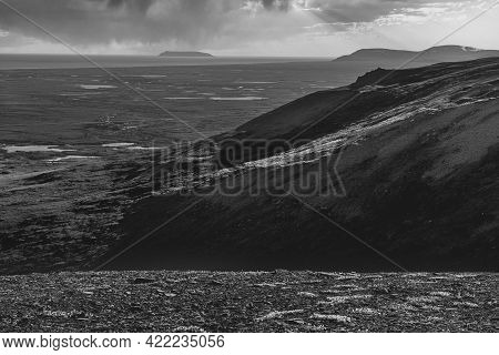 A Black And White Landscape With Sledge Island Off Nome Alaska In The Distance.