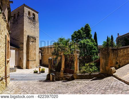 Narrow Old Town Street And Woman Walking Next To A Public Garden. Sepulveda Castilla.