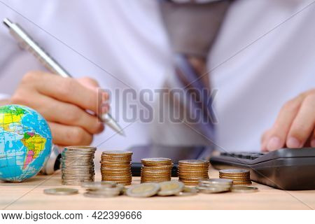 Businessman Using Caculator Income Saving Money And Investment Concept. Money Coin Stack Growing Gra