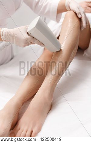 Close Up Of Legs Laser Hair Removal Procedure Conducted By Beauty Clinic Specialist In Gloves. Beaut