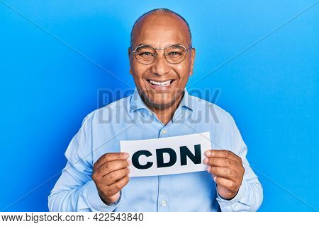 Middle age latin man holding cdn message paper smiling and laughing hard out loud because funny crazy joke. 