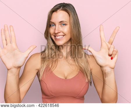 Beautiful caucasian woman wearing casual clothes showing and pointing up with fingers number eight while smiling confident and happy. 