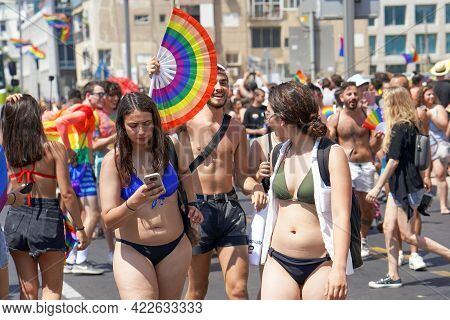 Gay And Lesbians Walking In The Gay Pride Parade. Parade Of Tolerance. Rainbow Flags At Gay Pride Pa