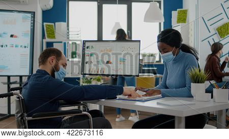 Invalid Businessman And African Employee With Protective Mask Against Coronavirus Working Together A
