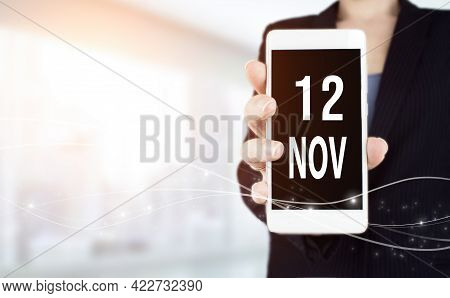 November 12nd. Day 12 Of Month, Calendar Date. White Smartphone With Calendar Date In Businesswoman 