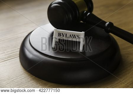 Bylaws Phrase With Gavel On Wooden Background. Business And Law Concept