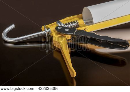 Glue And Sealant Gun With Reflection On Black Background. Construction Tool For Silicone And Glue. C