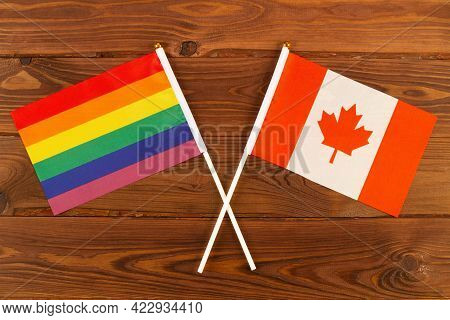 Rainbow Flag Lgbt And Flag Of Canada On Brown Wood Planks Background. Lgbt Pride Month. Lgbtq. Lgbtq