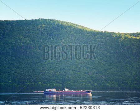 Barge on volga river under forest on mountain