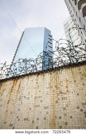 Dirty wall and barbwire in modern city