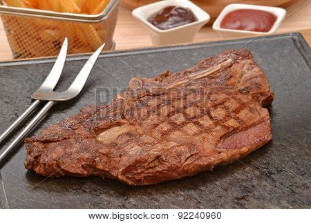 Grilled beef steak on stone and fried potatoes 