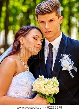 Bride and groom holoding bouquet of flower summer  outdoor.