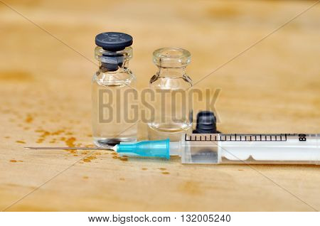Medical Vials For Injection And Syringe On Wood Table Background