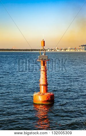 Navigation red buoy at the edge of a fairway.