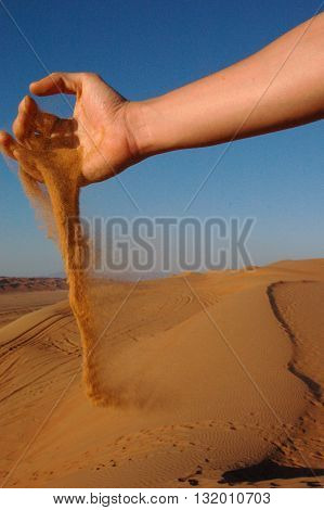 Sand Grains Slipping and Falling Through Hand