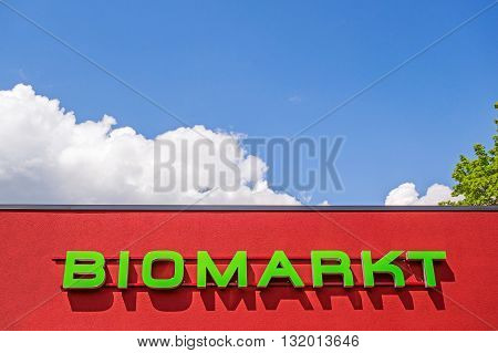 Heidenheim, Germany - May 26, 2016: Organic food market / bio market, red facade labeled with "BIOMARKT", german language, blue sky with clouds