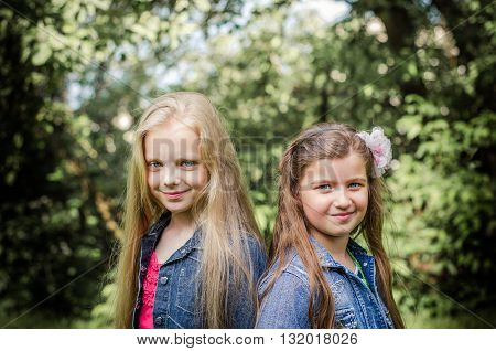 Portrait of two long haired preteen girls while smiling.