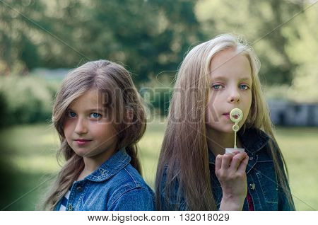 Portrait of two cute little girls enjoying summer outdoors.