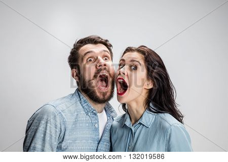 Close up photo of screaming man and woman on gray
