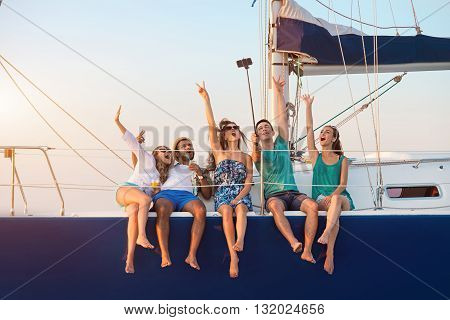 Cheerful people with selfie stick. Men with women on yacht. Remember this moment. Happiness that comes from heart.