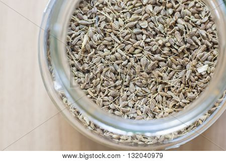 Glass jar with anise over wooden surface. Selective focus. High angle view