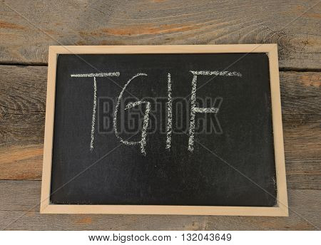TGIF written in chalk on a chalkboard on a rustic background