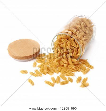 Glass jar filled with dry rotini yellow pasta over isolated white background