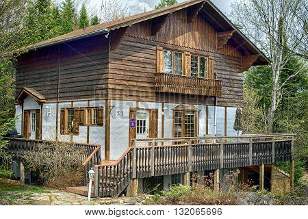 Laurentides, Quebec, Canada - May , 20, 2016: Wooden style house in the mountain for rent 3 stars - Tourist Quebec in Canada Laurentides, Quebec, Surrounded by green forest in Summer