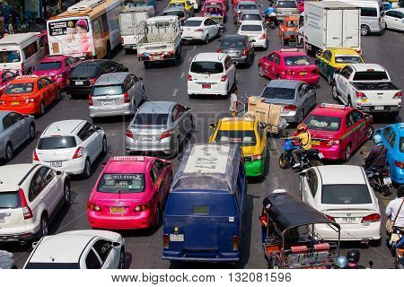 BANGKOK THAILAND - JANUARY 22 2015: Traffic moves slowly along a busy road in Bangkok Thailand. Annually an estimated 150000 new cars join the already heavily congested streets of Bangkok.