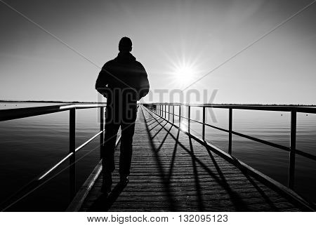 Man Silhouette Walk On Wharf Construction Above Sea To Sun. Fantastic Morning.