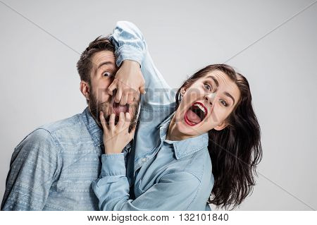 Close up photo of screaming man and woman on gray