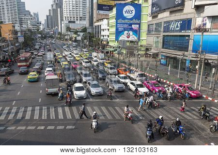 BANGKOK THAILAND - APR 29 : people walk across crosswalk in traffic at Asoke junction on april 29 2016 thailand. traffic jam is one of worse issue of Bangkok
